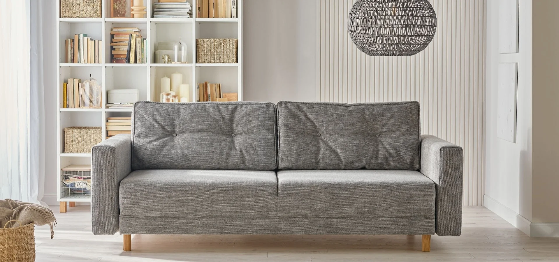 Szafa sofa z podłokietnikami na tle białej ściany